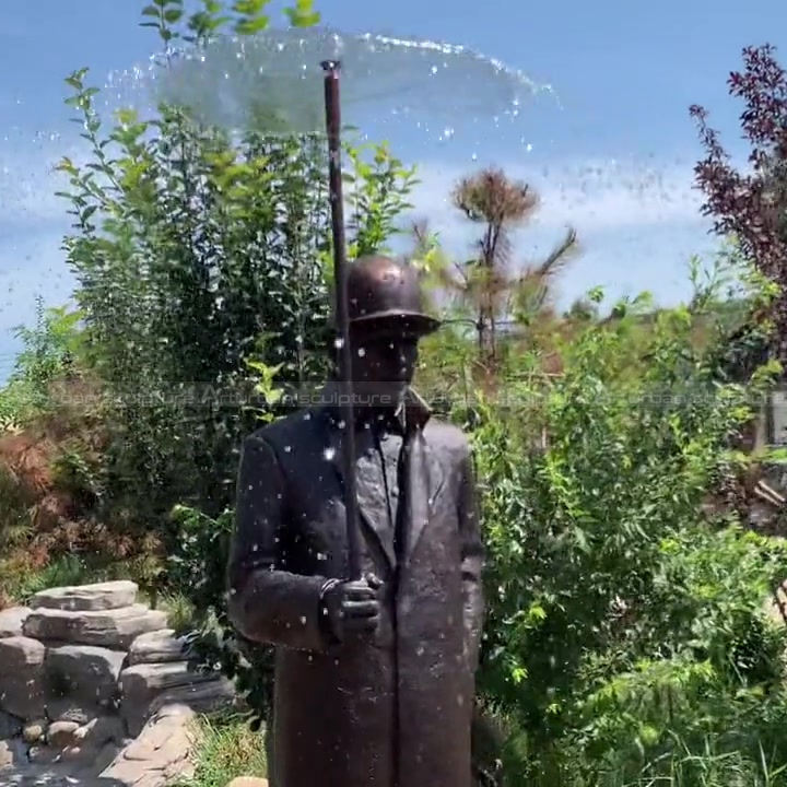 man statue with umbrella fountain