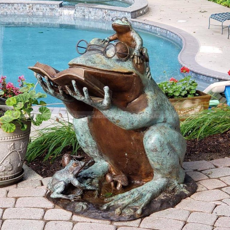 statua da giardino di una rana che legge