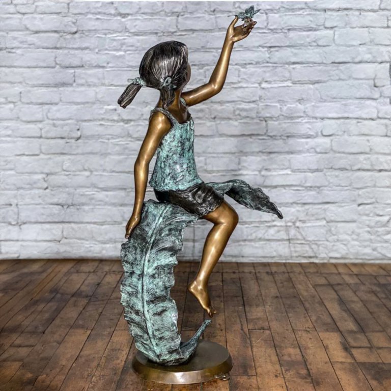 Estatua grande de niña con mariposa