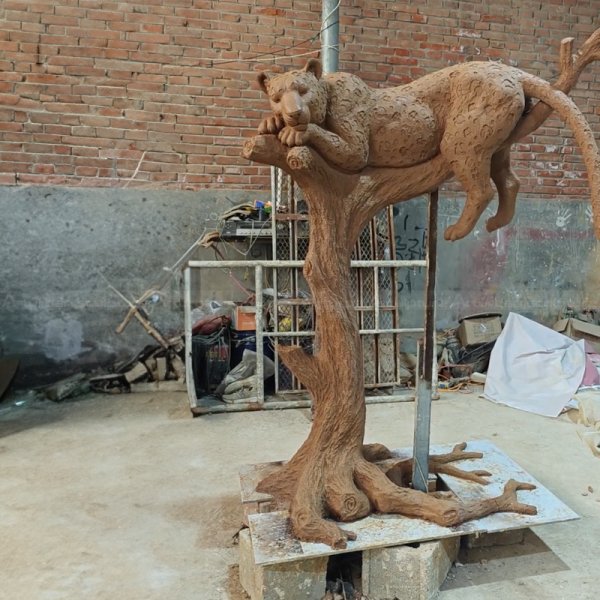 Large Jaguar Statue laying on a tree branch