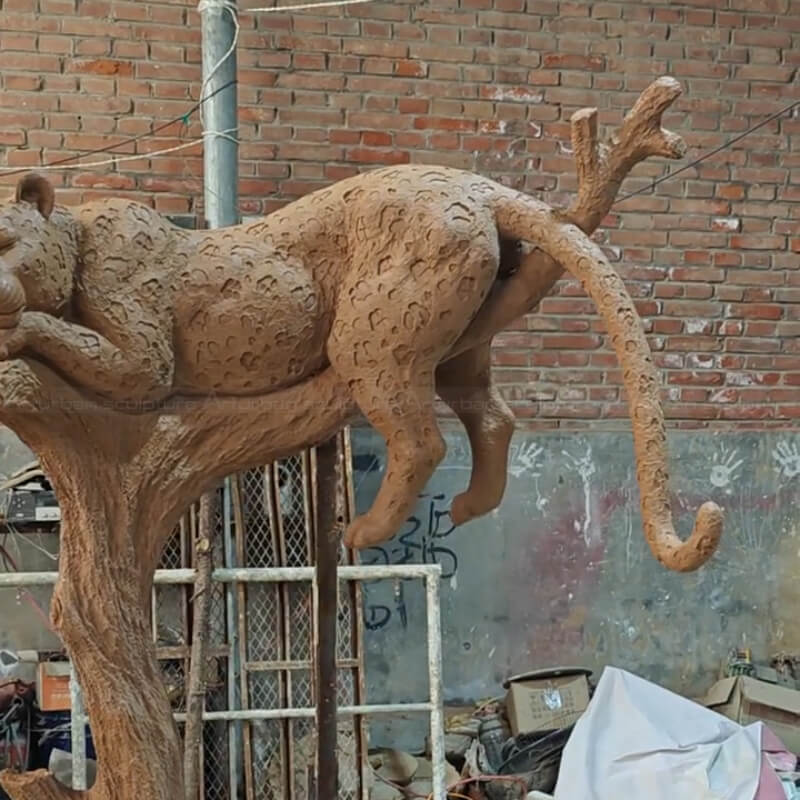 Large resting jaguar Statue with its tail hanging down