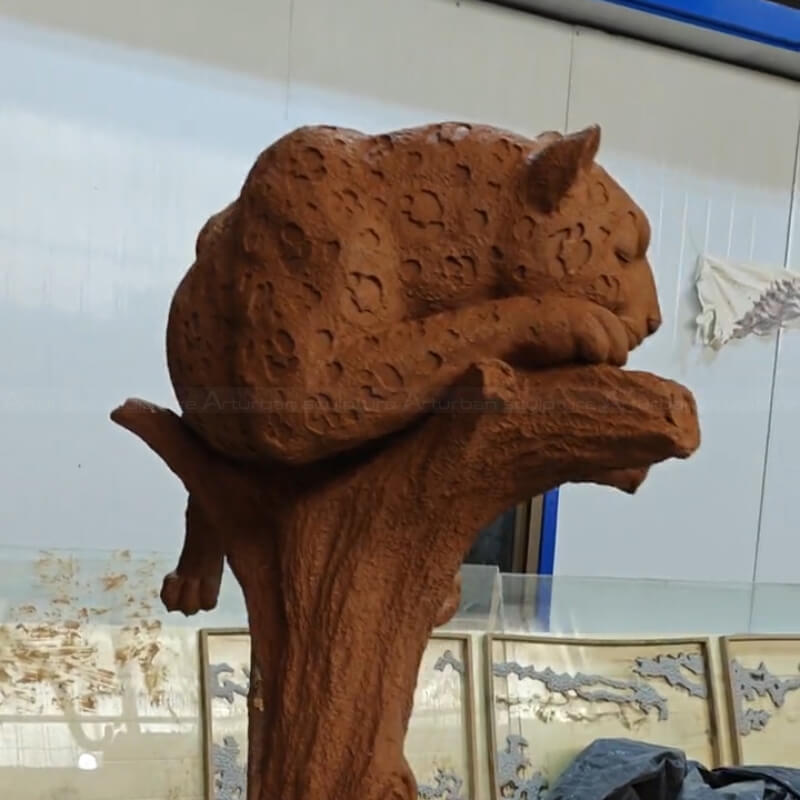 clay sculpture of a Large jaguar resting on a tree