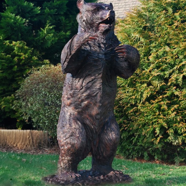 Grande scultura di orso in bronzo in piedi in una posizione allerta e difensiva
