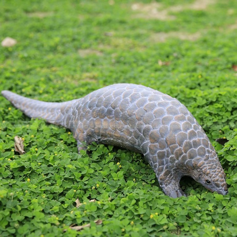 Statua di Pangolino in bronzo con la testa abbassata come se cercasse cibo