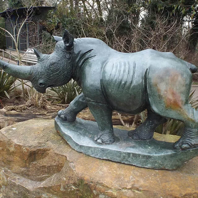 bronze Rhino Yard Art capturing the animal's strong and dynamic posture with detailed muscle lines, skin textures