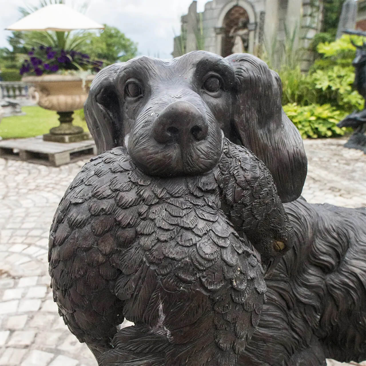 close up view of Labrador Retriever bronze Garden Statue highlighting the dog holding a bird in mouth
