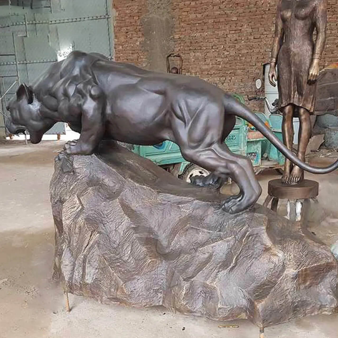 side view of Panther Bronze Statue standing on a rock with its mouth open and sharp teeth visible
