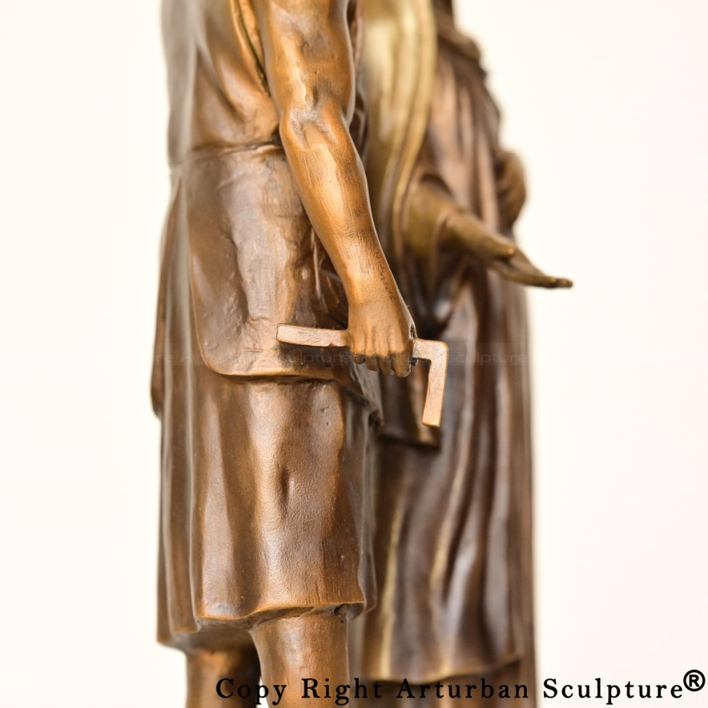 mary and joseph bronze statue highlighting Joseph holding a small carpenter’s square in his right hand