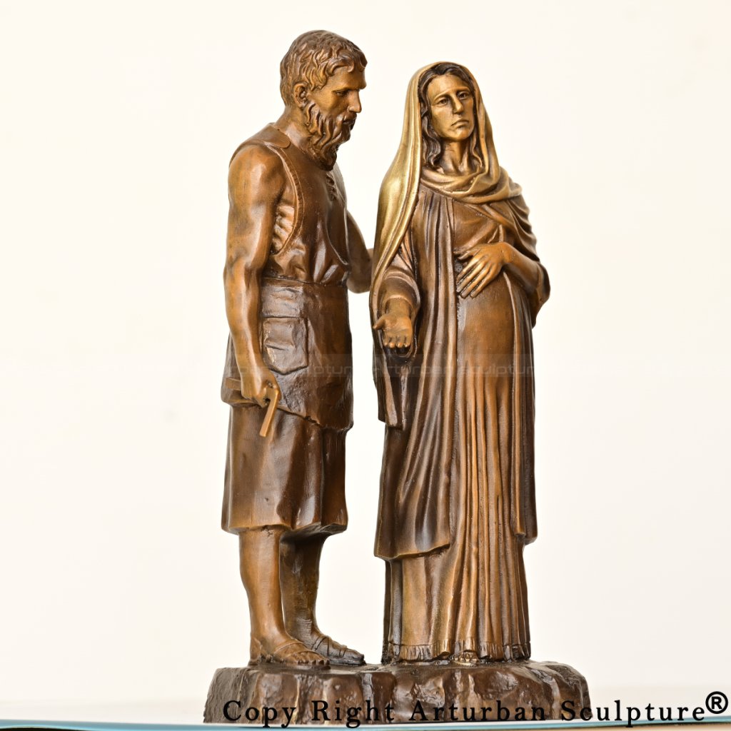 bronze Mary and Joseph statue, depicting Joseph holding a square and Mary with one hand on her pregnant belly