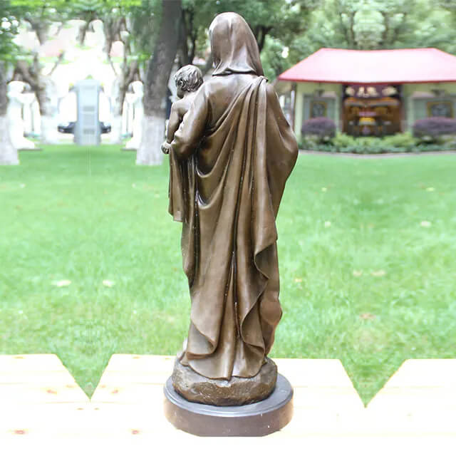 Back view of the sculpture of Mother Mary holding baby Jesus