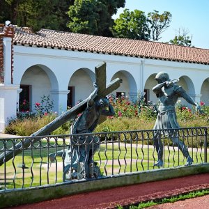 Bronze Passion of Christ Statue depicting Jesus carrying the cross while being guarded by a Roman soldier