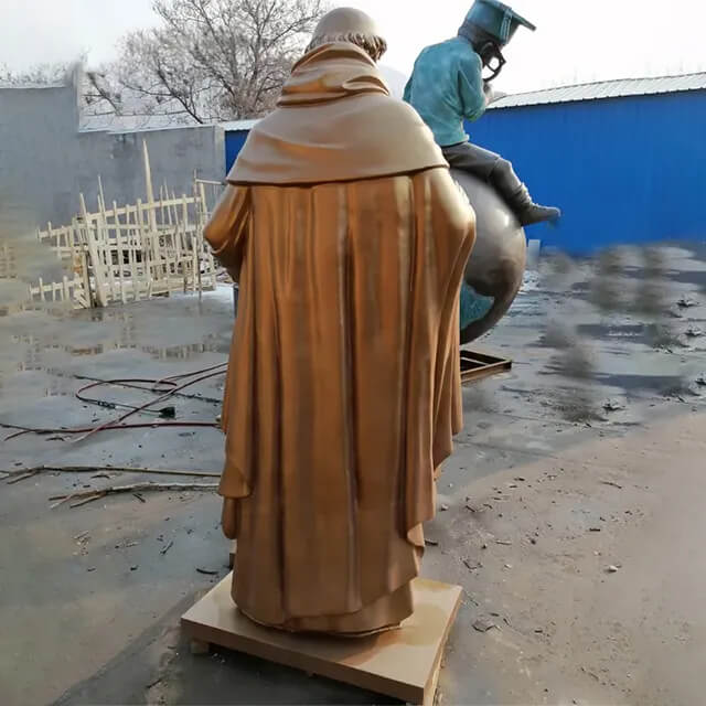 Bronze back view of Aquinas Statue, depicting the flowing robe of the saint