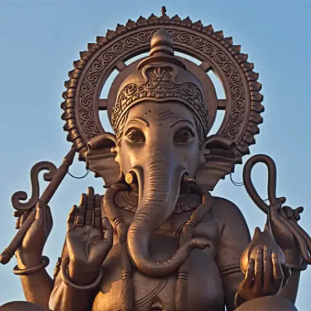 Close-up of a bronze Lord Ganesha Sculpture featuring detailed elephant head, ornate crown, and metal halo