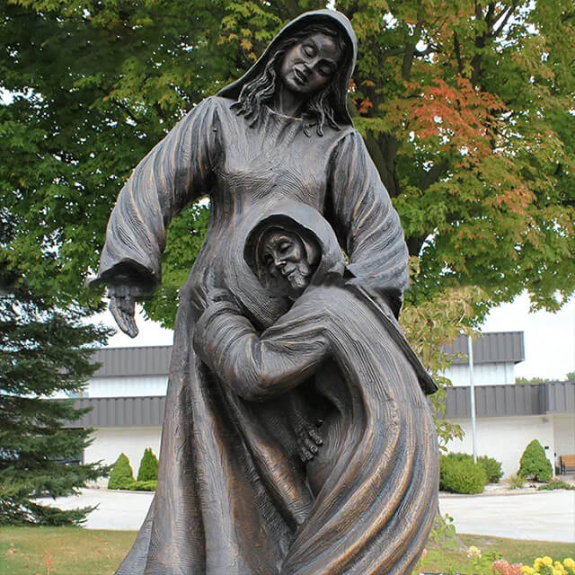 Close-up view of the bronze Visitation Statue showing Elizabeth embracing the Virgin Mary with joy