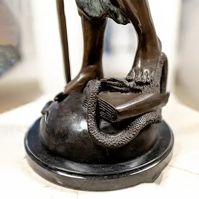 Detail of the base of a Statue of Blindfolded Lady, with a snake wrapped around a law book beneath her feet