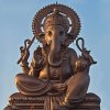 Frontal view of a large bronze Lord Ganesha Sculpture seated in a blessing pose with symbolic items in four arms