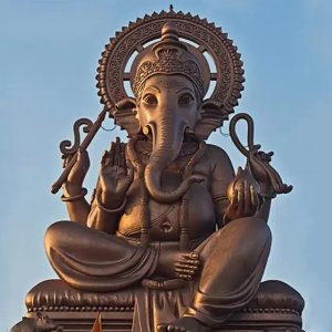Frontal view of a large bronze Lord Ganesha Sculpture seated in a blessing pose with symbolic items in four arms