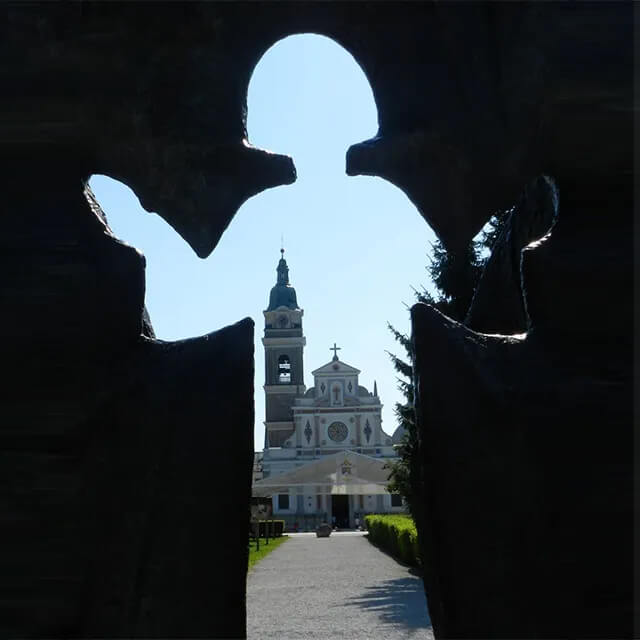 View of the Basilica through the negative space of a Large Holy Family Statue in Brezje, Slovenia