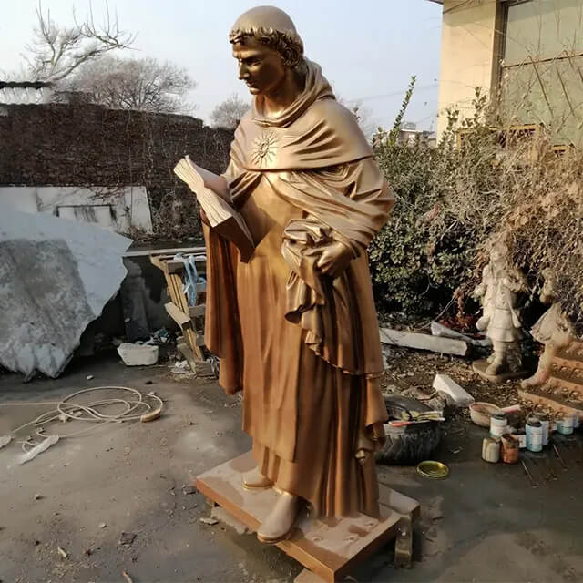 bronze Aquinas Statue, holding a book in his left hand and gathering his robe in his right