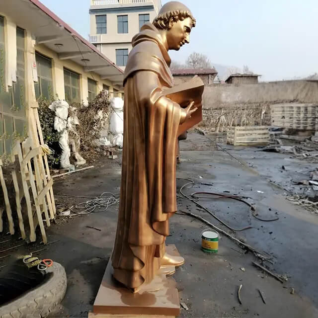 bronze Aquinas Statue, holding a book in his left hand
