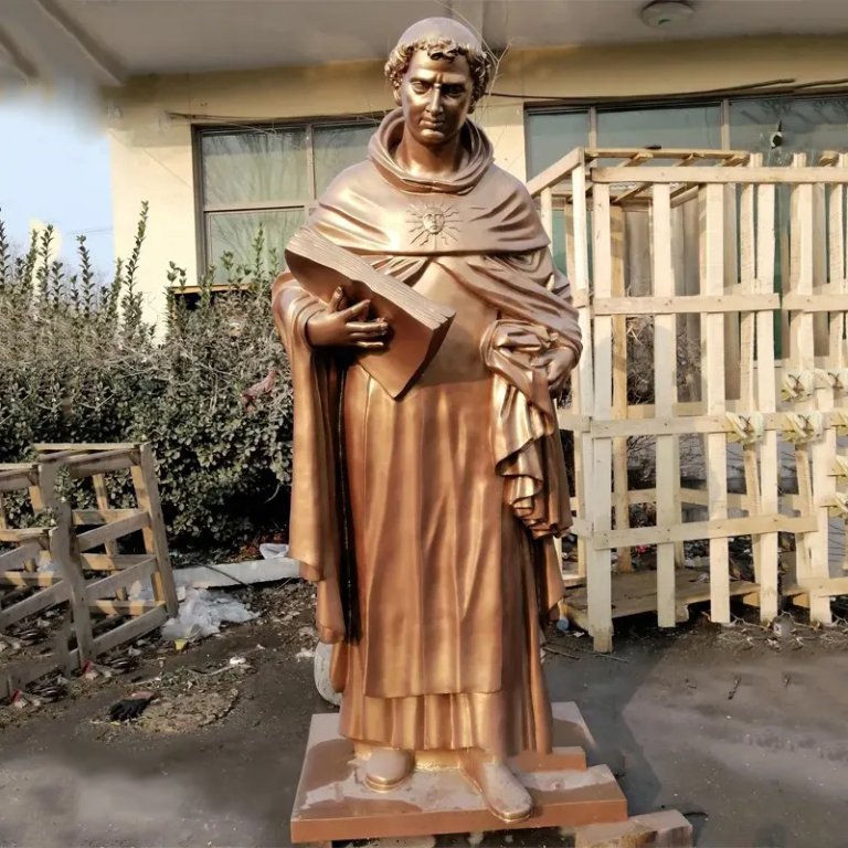 bronze Aquinas Statue with serene expression, holding a large book