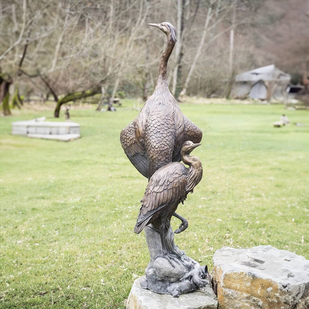 Blue Heron Bronze Sculptures showing two great blue herons perched on a tree base