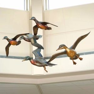 Bronze Mallard Statue with ducks spiraling upward and beavers resting at the base