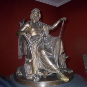 Odin Bronze Statue showing the Norse god Odin seated on a throne with two wolves at his feet and a raven on the chair
