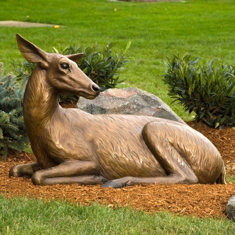 Outdoor Deer Sculpture in bronze, depicting a lifelike doe lying down with delicate fur texture