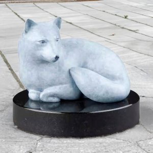 bronze Arctic Fox Statue featuring a minimalist white fox curled on a black marble base