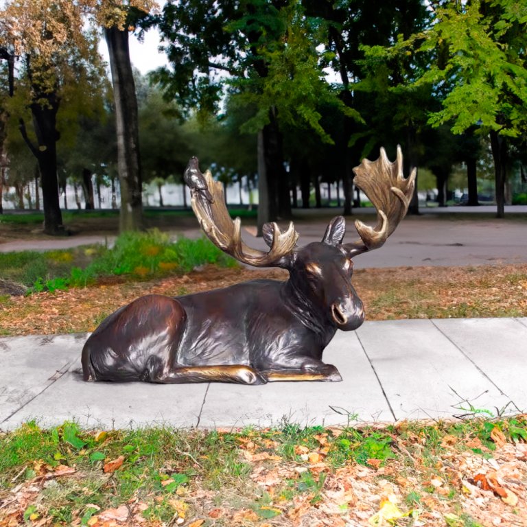 Lifelike bronze Moose Yard Statue featuring a reclining moose with a bird perched on its antlers