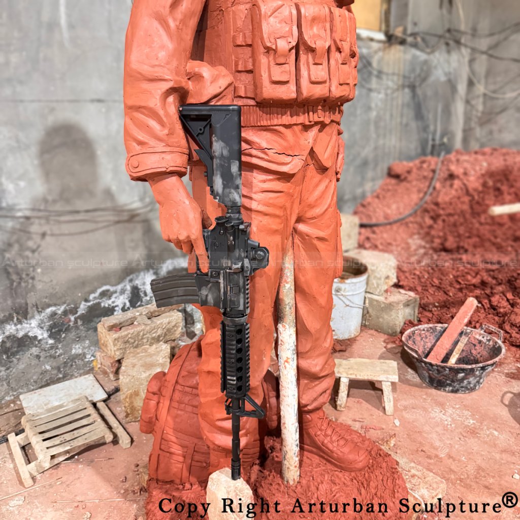 3-close-up of rifle and lower body on the Female Soldier Statue clay sculpture in progress
