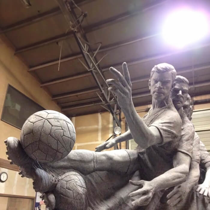 A bronze sculpture capturing Motion in Sculpture with a dynamic soccer action scene