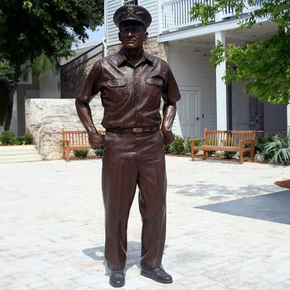 Admiral Nimitz Statue outdoors, hands in pockets, in bronze naval uniform