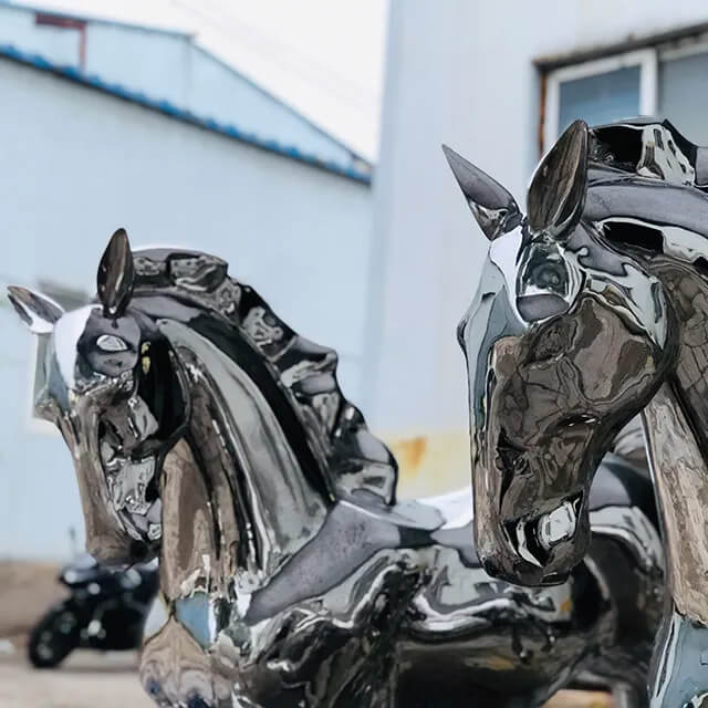 Close-up view of two stainless steel horse sculptures