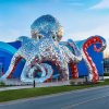 Giant Octopus Sculpture wrapping around the entrance with shiny stainless steel textures