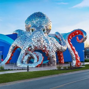 Giant Octopus Sculpture wrapping around the entrance with shiny stainless steel textures