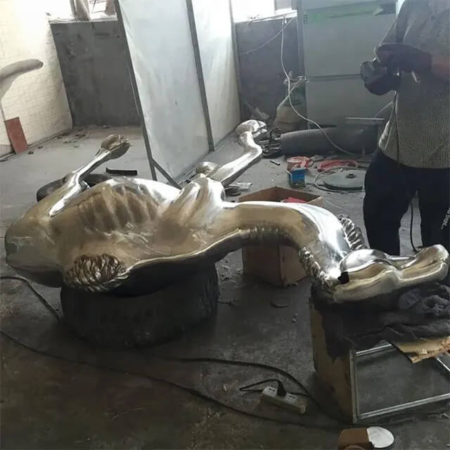 Stainless steel camel statue being crafted in workshop