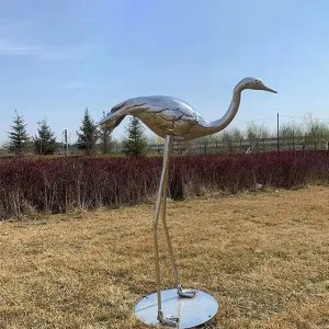 Stainless steel crane bird feeding on lawn, elegant metal crane bird lawn art