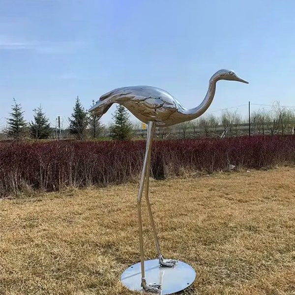 Stainless steel crane bird feeding on lawn, elegant metal crane bird lawn art