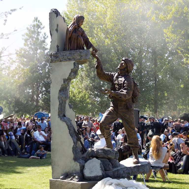 bronze composition of a soldier extending his arms to a child above, designed as a meaningful soldier statue for garden display