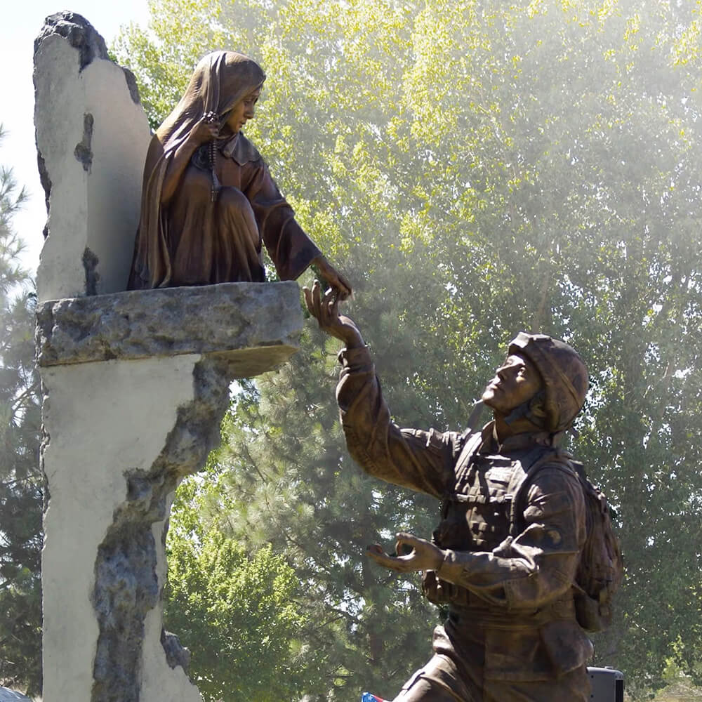 bronze soldier statue for garden showing a U.S. soldier reaching toward a child seated on a war-damaged wall