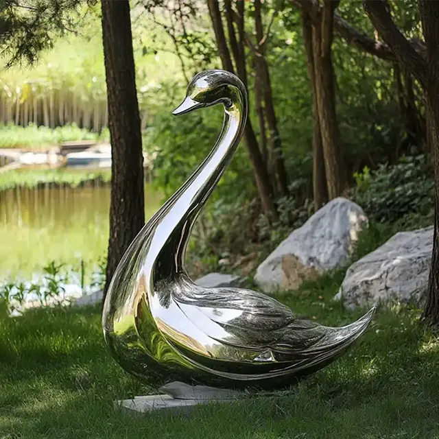 Elegant Stainless Steel Swan Sculpture displayed in a garden