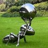 Stainless steel Ant Statue in a lawn garden holding a reflective sphere