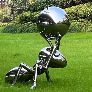 Stainless steel Ant Statue in a lawn garden holding a reflective sphere
