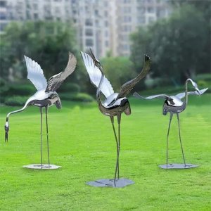 Three polished stainless steel Metal Garden Crane Statues with open wings