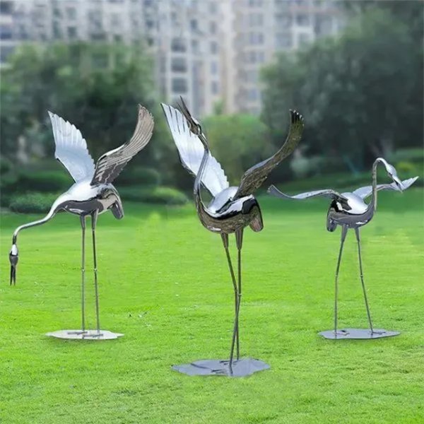Three polished stainless steel Metal Garden Crane Statues with open wings