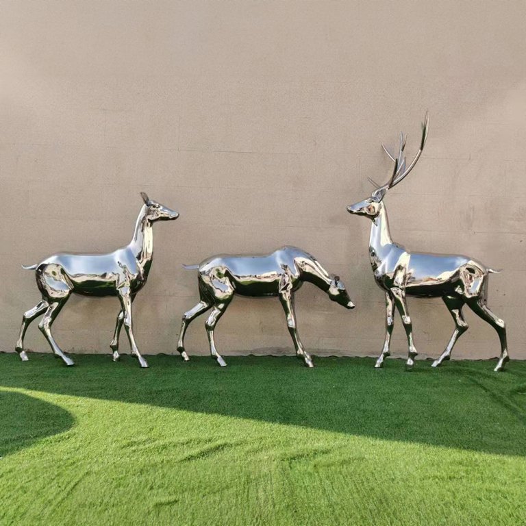 Um grupo de Esculturas de Cervo em Aço Inoxidável apresentando um cervo com galhadas e duas fêmeas