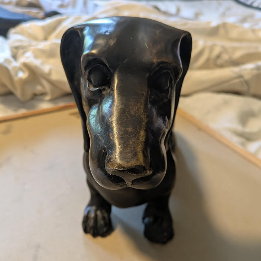 Estatua conmemorativa de bronce de un perro salchicha con expresión leal