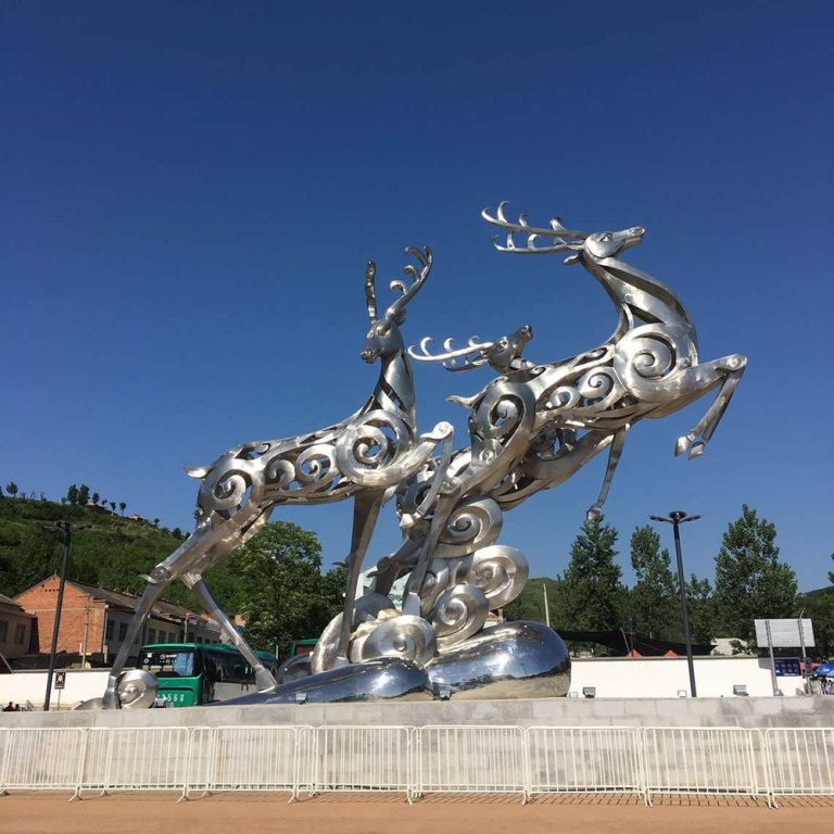 Large Deer Sculpture made of polished stainless steel, featuring three leaping deers with abstract swirl patterns
